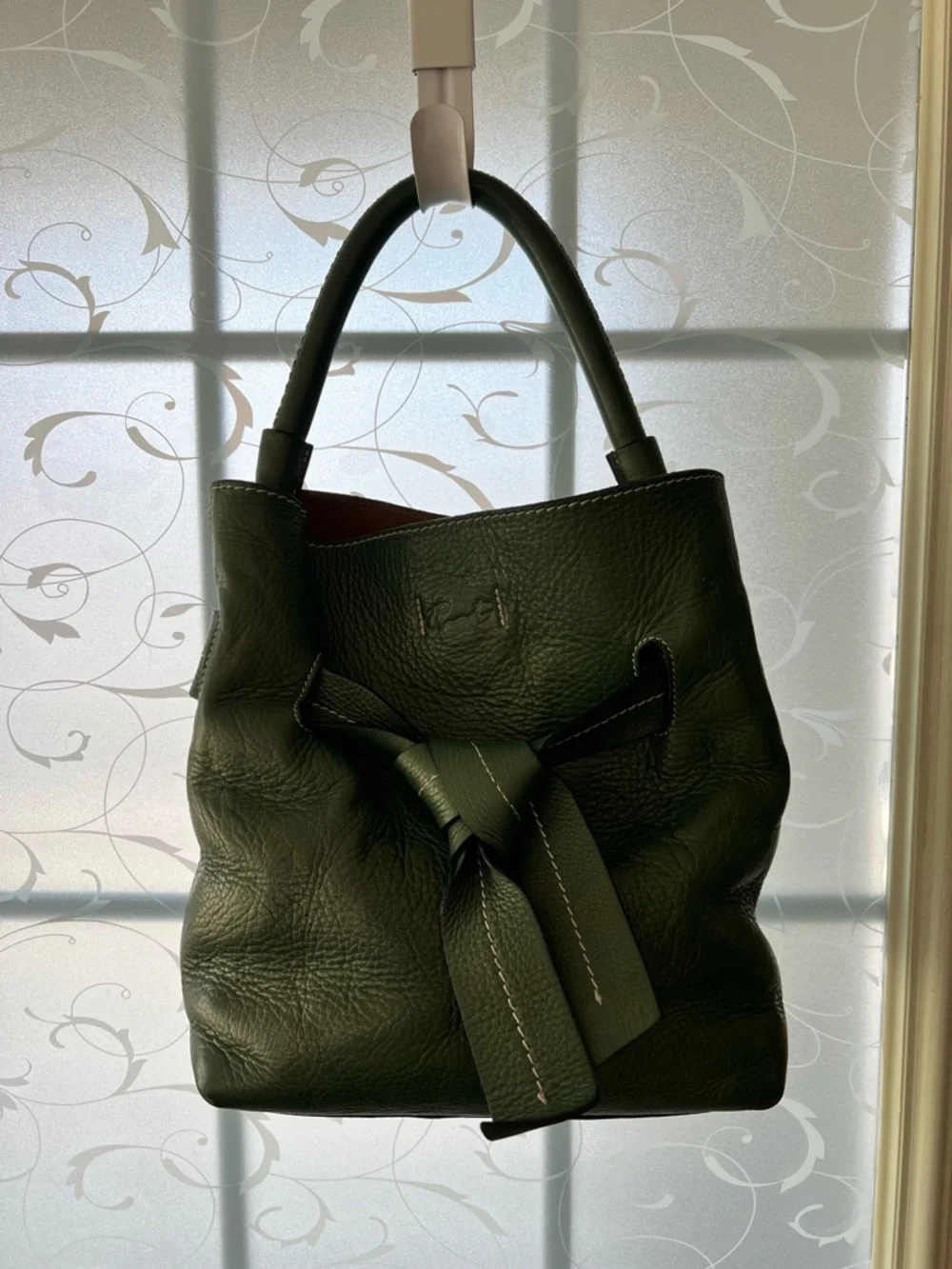 Tramontano hand bag in a pebbled green with a slight shimmer. Magnetic closure.